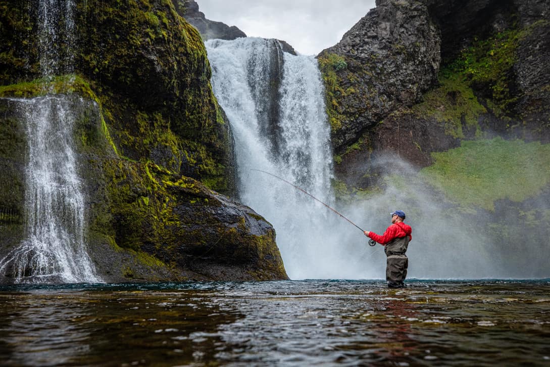 Fly fishing near waterfall in Iceland